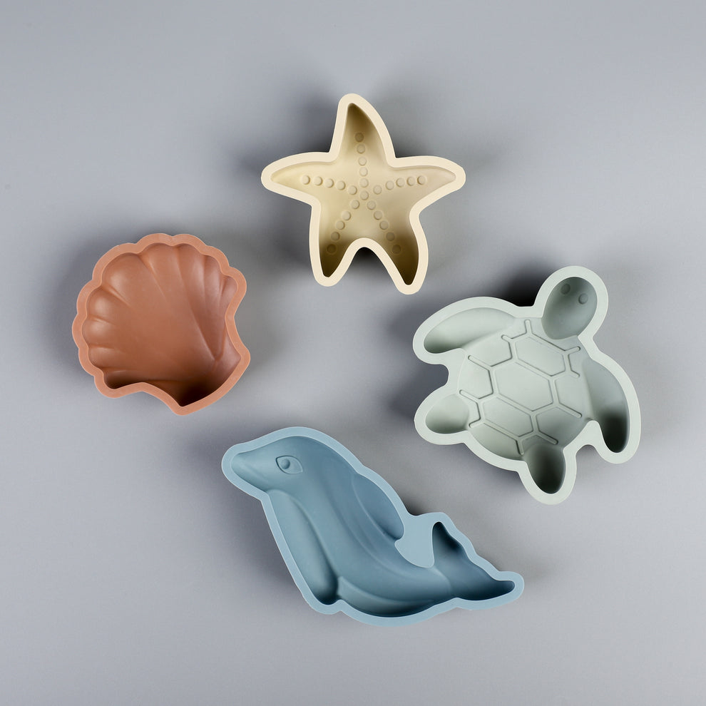 The four sand molds from the Beach Bucket Set: shell, starfish, turtle, and whale.
