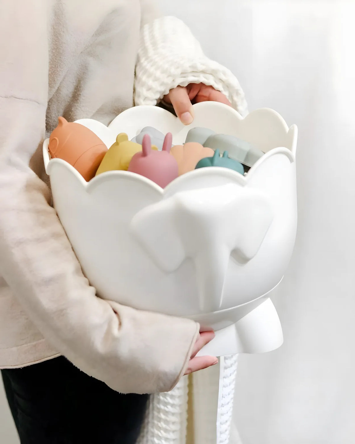Hands holding Bath Buddy with silicone bath toys in the bowl