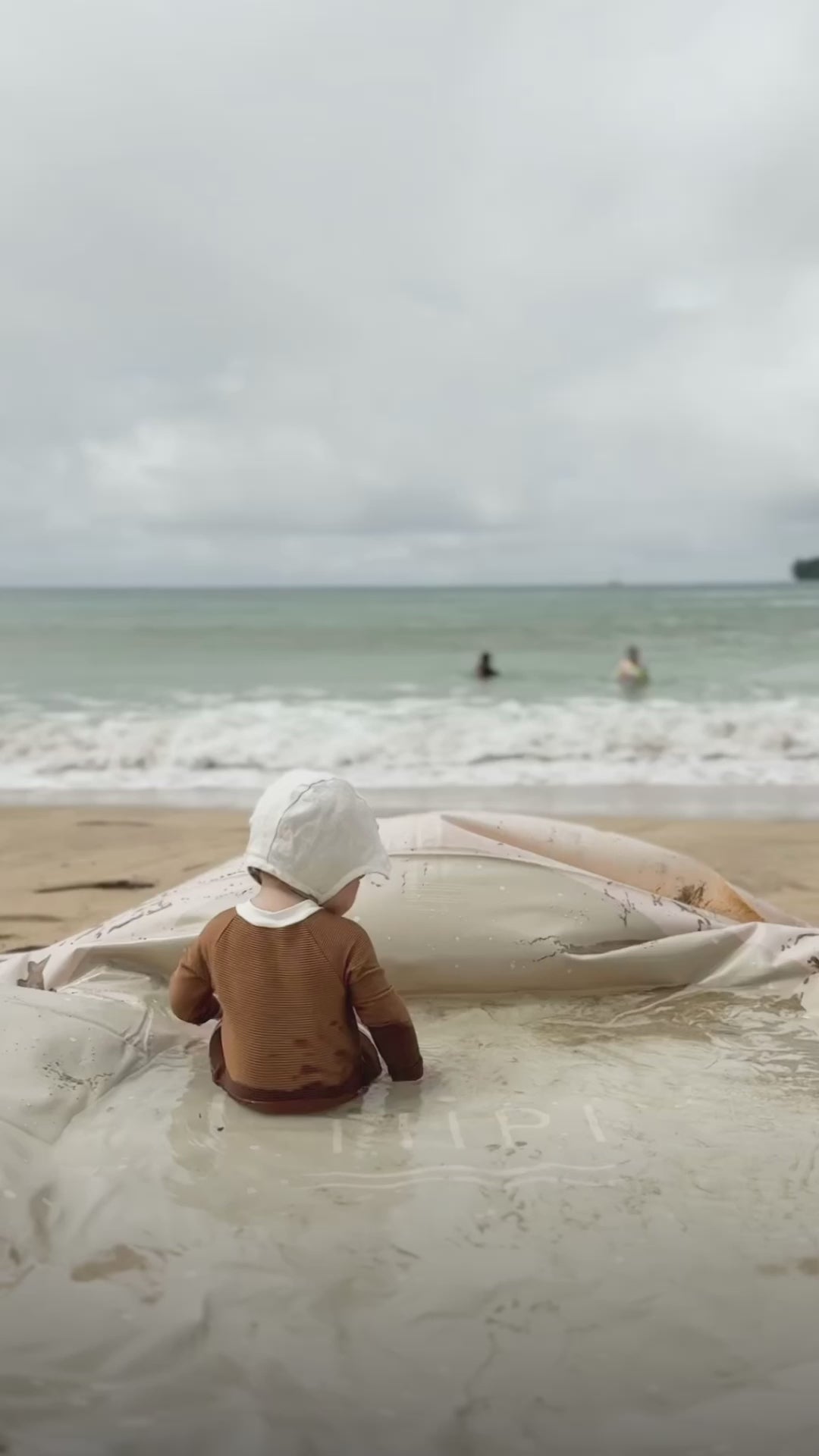 Toddler sitting in the Tiipikids portable baby pool at the beach — no-hose kiddie pool for travel and outdoor backyard play