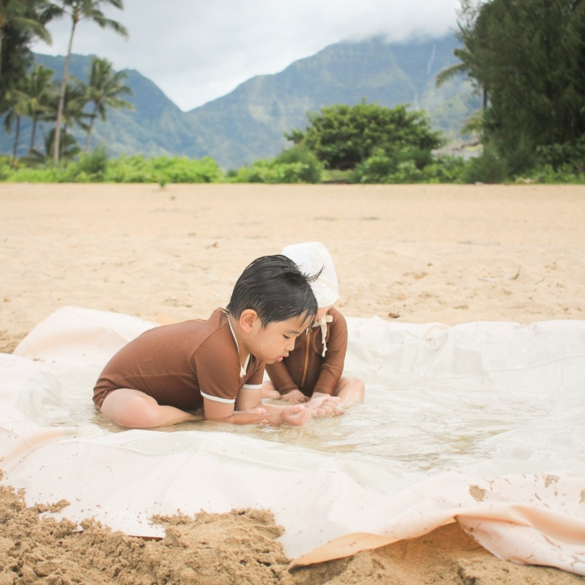 Toddler playing in the Tiipikids Beach Pool — portable kiddie pool on a sandy beach, perfect outdoor summer toddler toy
